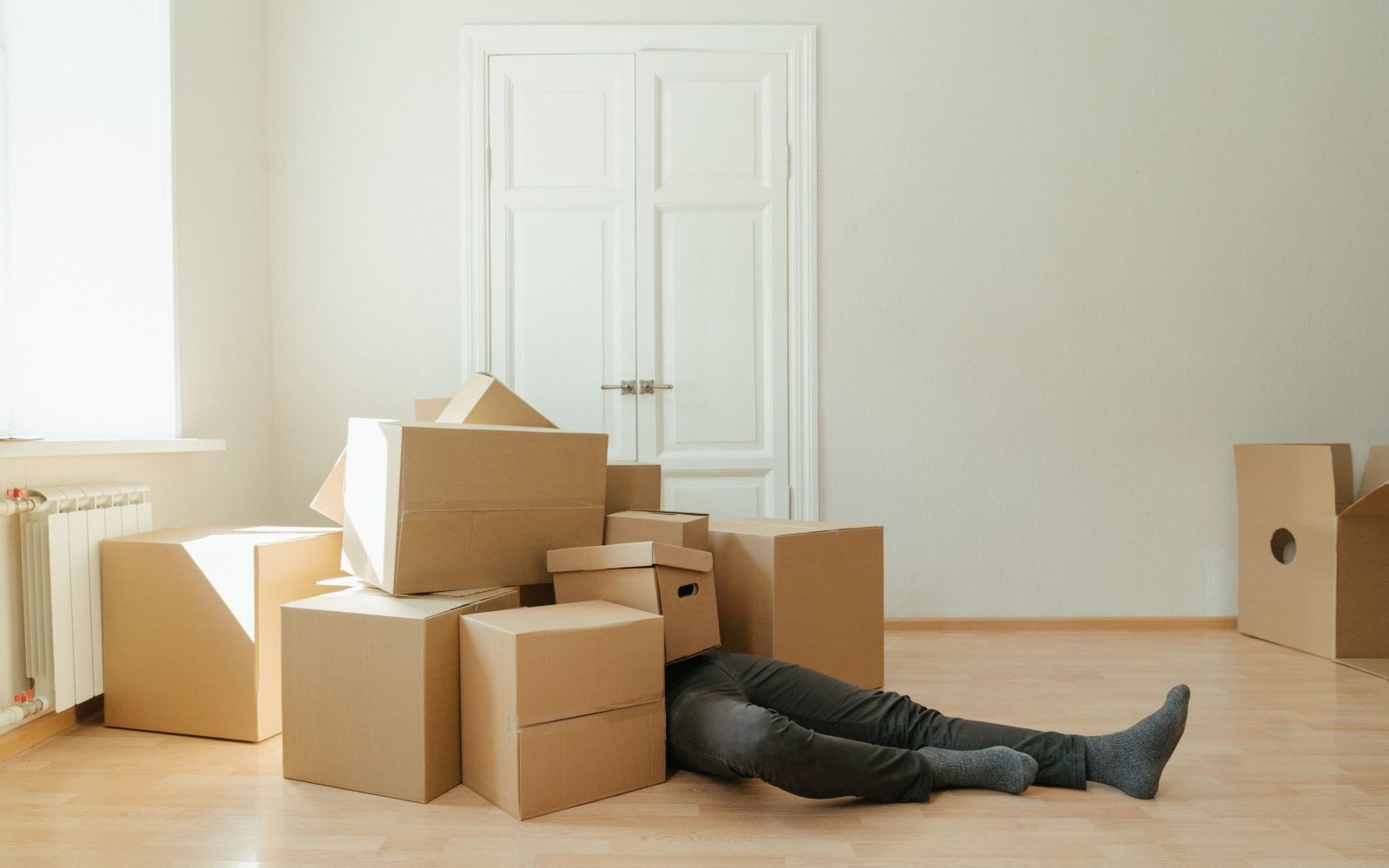 Mitarbeiter trägt Umzugskartons aus einer Wohnung
